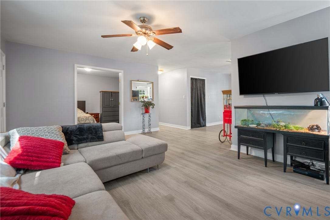 3940 Three Bridge Road, Powhatan, VA 23139 Spacious living area featuring light gray wall paint, wood-finish flooring, and an overhead ceiling fan