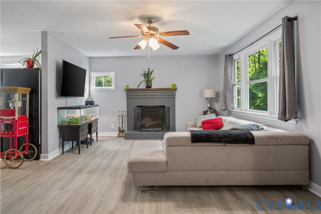 3940 Three Bridge Road, Powhatan, VA 23139 Living area featuring wood-finish flooring, a fireplace with a mantel, multiple windows, and a ceiling fan