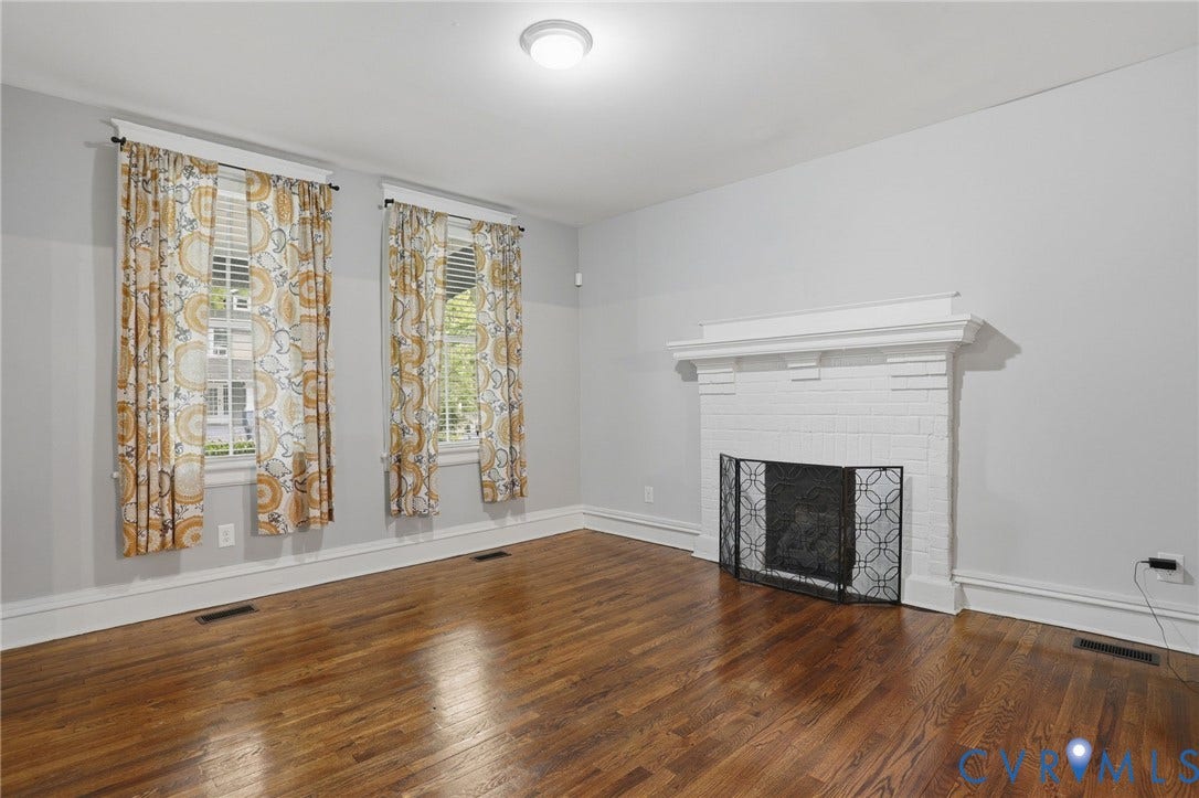 3110 3rd Avenue, North Highland Park, Richmond, VA 23222 Hardwood flooring complements a white brick fireplace with a decorative screen