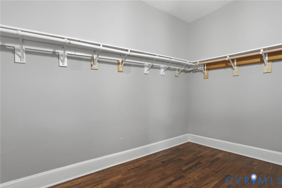 3110 3rd Avenue, North Highland Park, Richmond, VA 23222 Closet space featuring wood-finish flooring, light gray wall paint, white baseboards, and built-in shelving with hanging rods