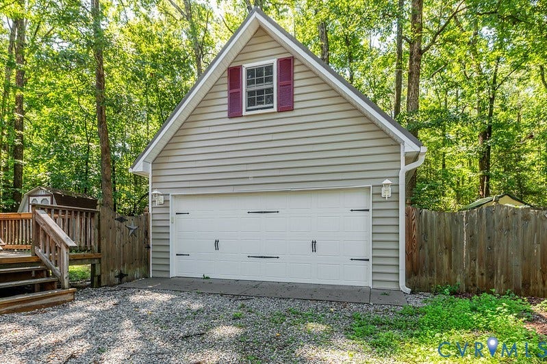 9007 Chatham Grove Lane, Richmond, VA 23236 Detached garage structure with horizontal siding, a white garage door, and a second-story window with red shutters
