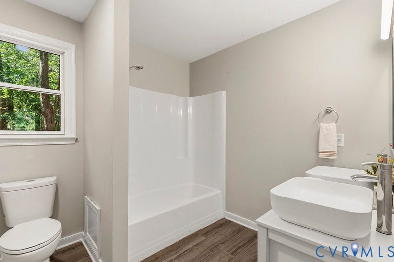 9007 Chatham Grove Lane, Richmond, VA 23236 Bathroom featuring a white vanity with a rectangular vessel sink, coordinating white toilet, and wood-finish flooring
