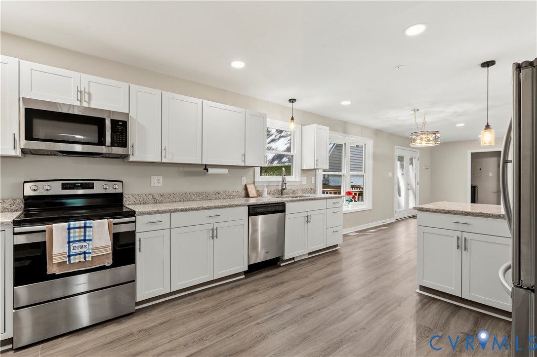 9007 Chatham Grove Lane, Richmond, VA 23236 Kitchen featuring wood-finish flooring, white cabinetry, stainless steel appliances, speckled countertops, and an island with built-in storage