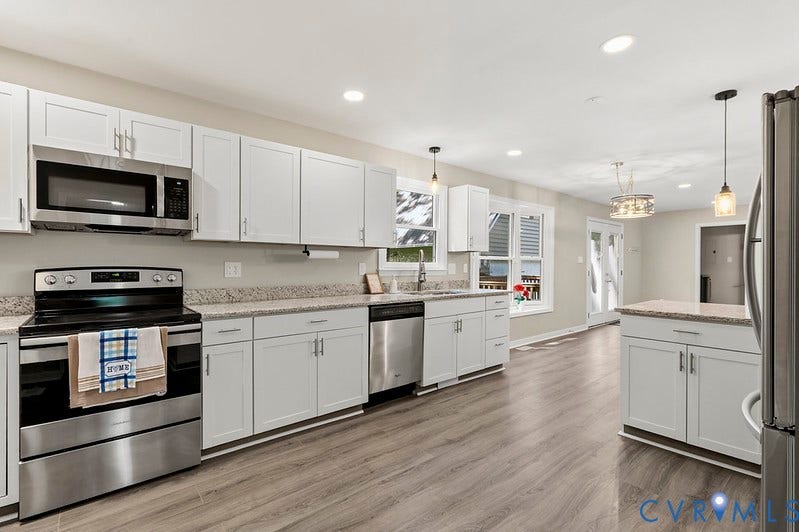 9007 Chatham Grove Lane, Richmond, VA 23236 White shaker cabinetry, stainless steel appliances, granite countertops, wood-finish flooring, and recessed lighting