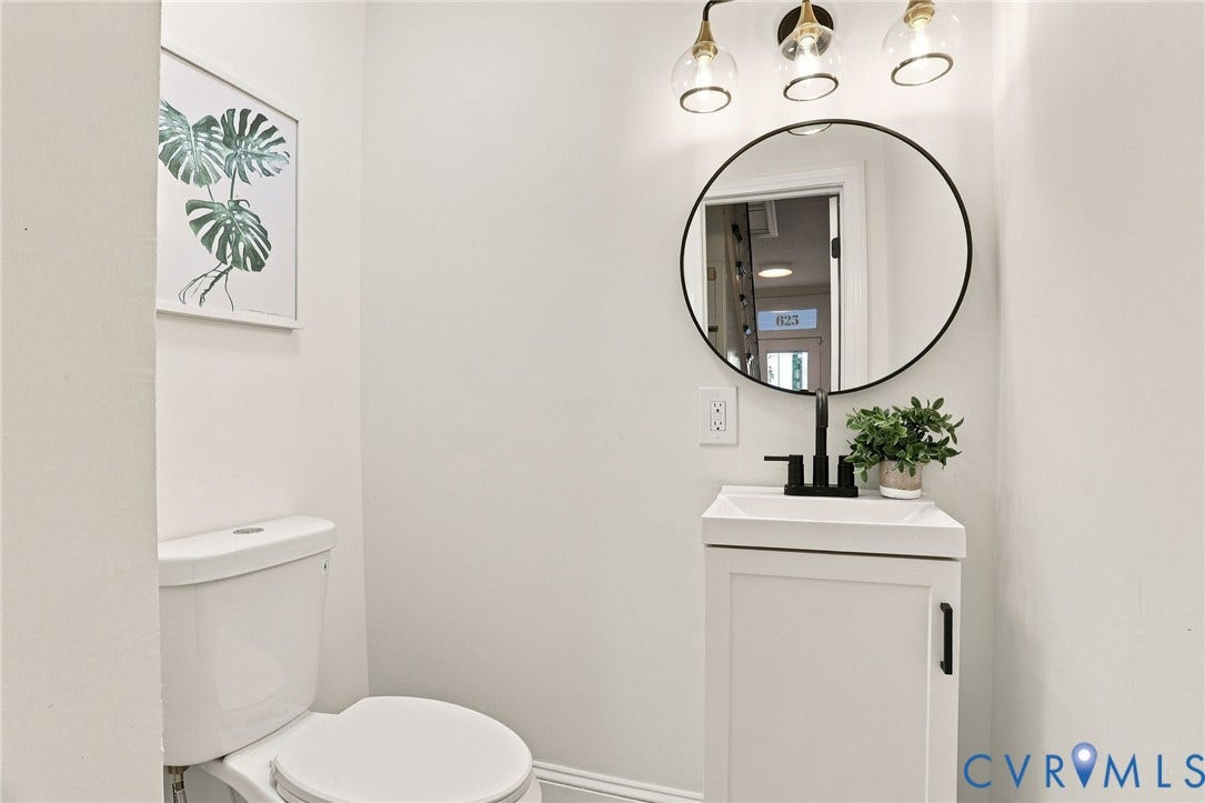 625 N 33rd Street, Chimborazo, Richmond, VA 23223 White vanity with a rectangular sink, matte black faucet, and a circular mirror with a black frame