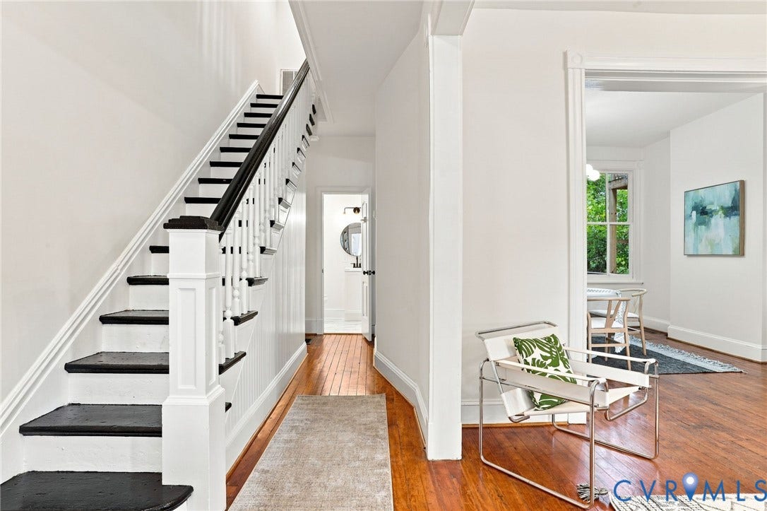 625 N 33rd Street, Chimborazo, Richmond, VA 23223 Hardwood flooring, painted staircase with dark treads and white risers, white paneled walls, and a recessed doorway
