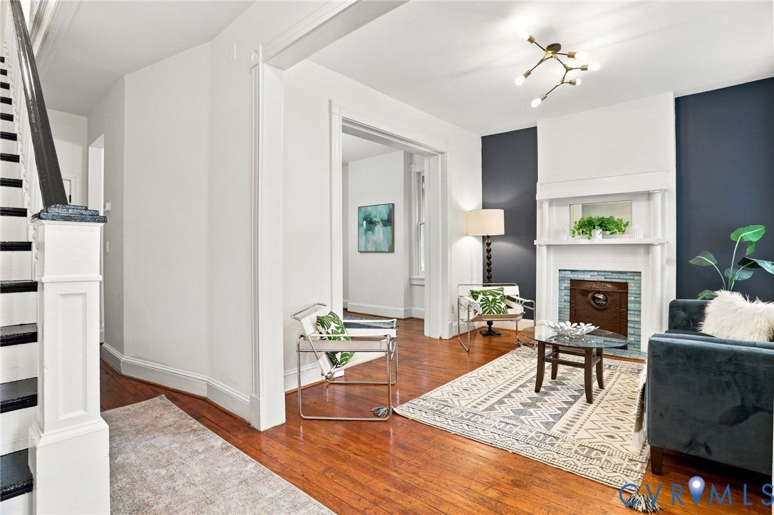625 N 33rd Street, Chimborazo, Richmond, VA 23223 Elegant living room featuring rich wood-finish flooring, a gas fireplace with built-in shelving and cabinetry, and crisp white architectural millwork