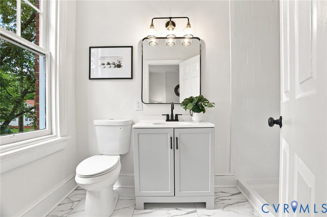 625 N 33rd Street, Chimborazo, Richmond, VA 23223 White paneled door with matte black hardware, vanity with an integrated sink and matte black faucet, and a wall-mounted mirror