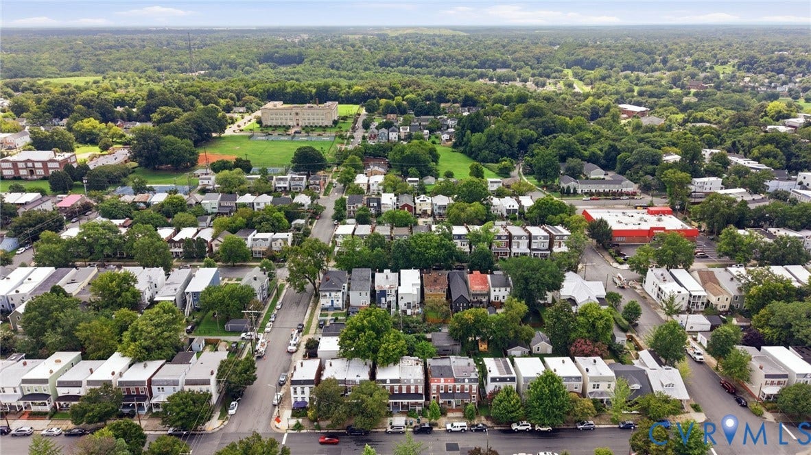 625 N 33rd Street, Chimborazo, Richmond, VA 23223 Aerial perspective of a developed neighborhood featuring residential properties, mature trees, and a distant institutional building with a sports field