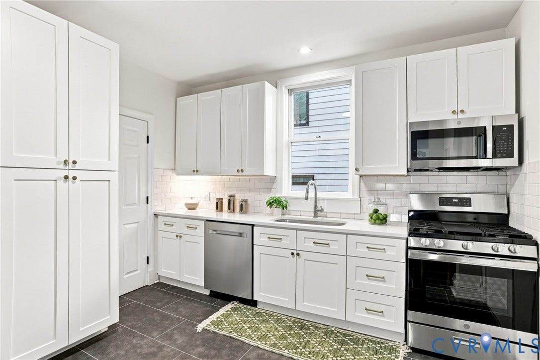 625 N 33rd Street, Chimborazo, Richmond, VA 23223 White shaker cabinetry with gold-tone hardware, stainless steel appliances, subway tile backsplash, and dark tile flooring