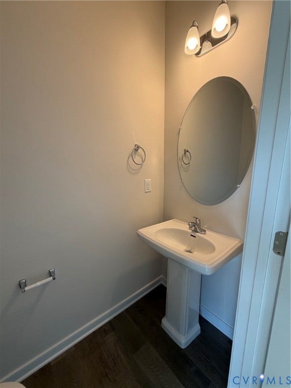 4184 Park Trail Drive, Henrico, VA 23223 Pedestal sink with chrome faucet, oval mirror, and contemporary two-light vanity fixture
