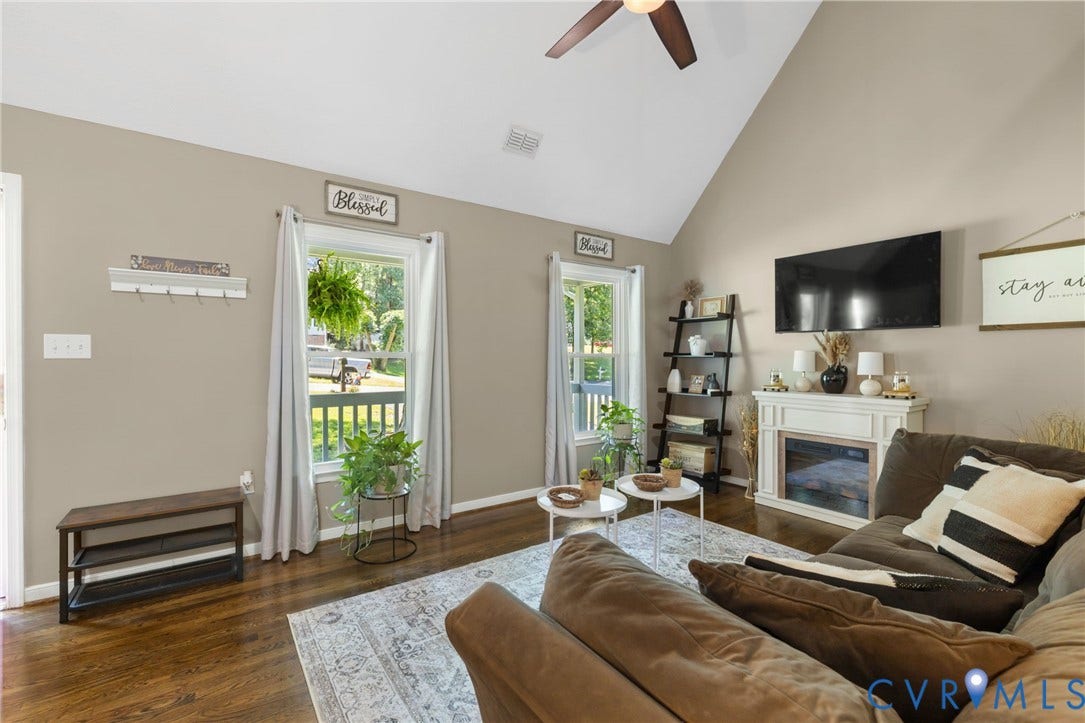 7306 Native Dancer Drive, Midlothian, VA 23112 Vaulted ceiling, ceiling fan, wood-finish flooring, white fireplace surround, and multiple windows