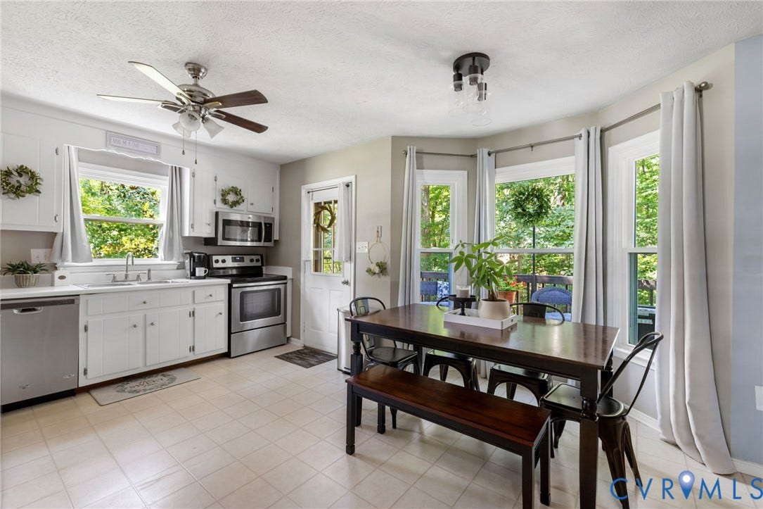 7306 Native Dancer Drive, Midlothian, VA 23112 White cabinetry with stainless steel appliances, tiled flooring, and multiple windows