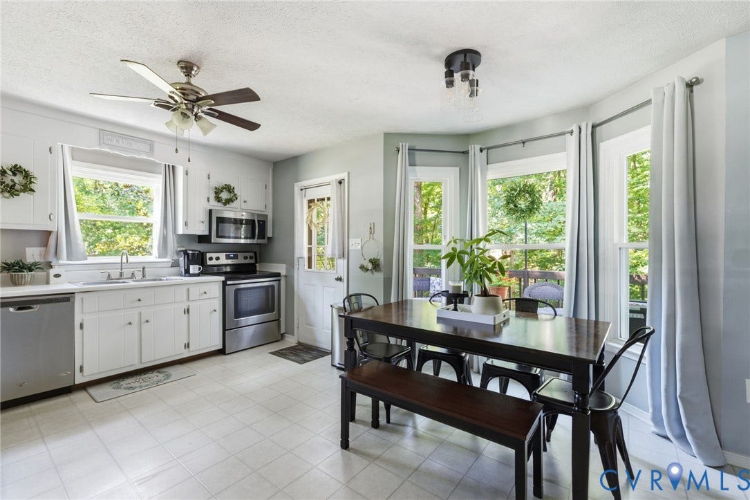 7306 Native Dancer Drive, Midlothian, VA 23112 White cabinetry, stainless steel appliances, bay window with multiple panes, ceiling fan, and tile flooring