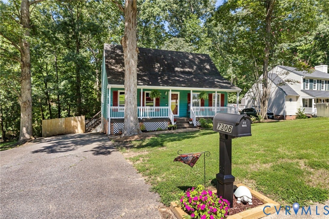 7306 Native Dancer Drive, Midlothian, VA 23112 Two-story residence with a covered front porch featuring white railings, red window shutters, and a dark shingle roof