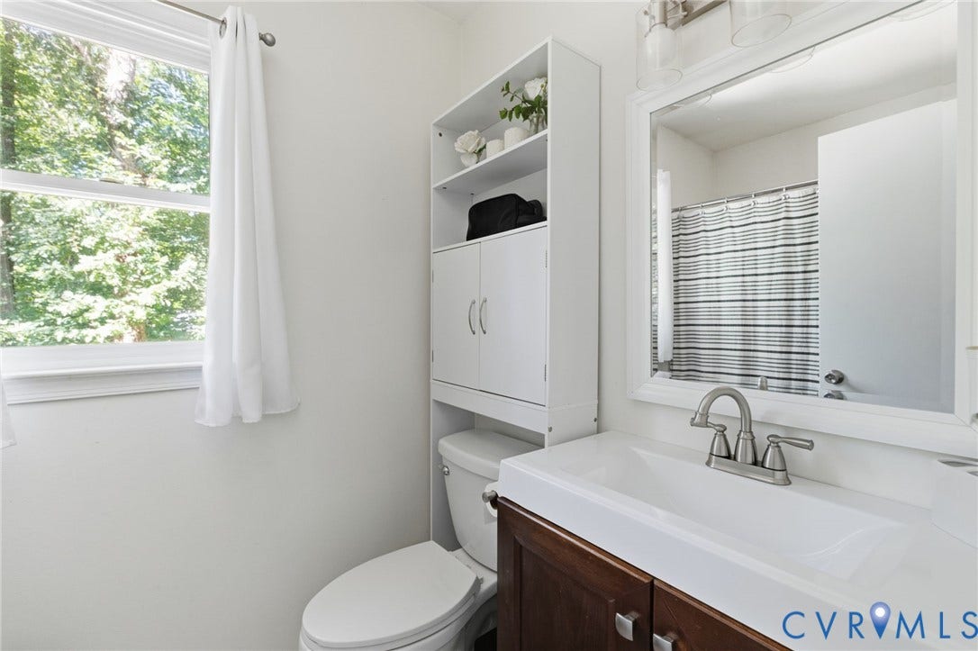 7306 Native Dancer Drive, Midlothian, VA 23112 Bathroom featuring a single window, white built-in storage shelving, a vanity with a white integrated sink, and a framed mirror