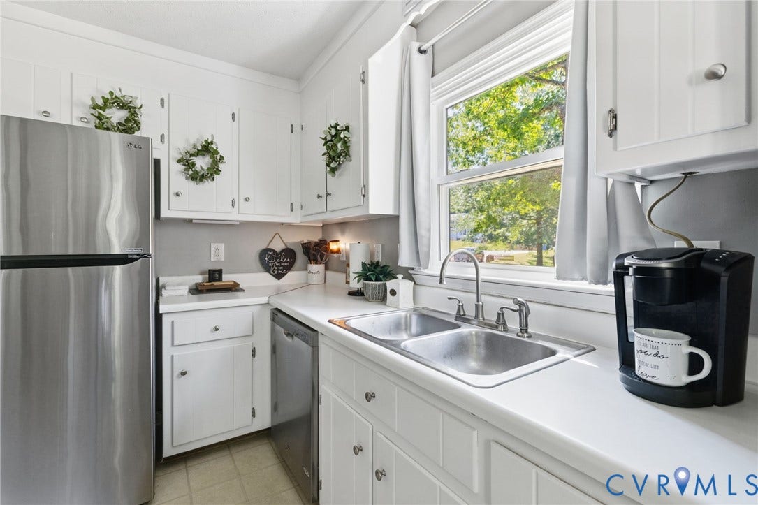 7306 Native Dancer Drive, Midlothian, VA 23112 White cabinetry, stainless steel appliances, double basin sink, light-toned countertops, and a window above the sink