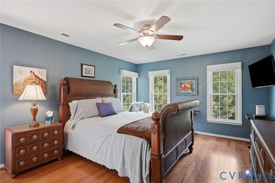 Elegant primary bedroom kissed with sunlight, but don't worry the windows feature valances with blackout shades.  Sleep in and enjoy!