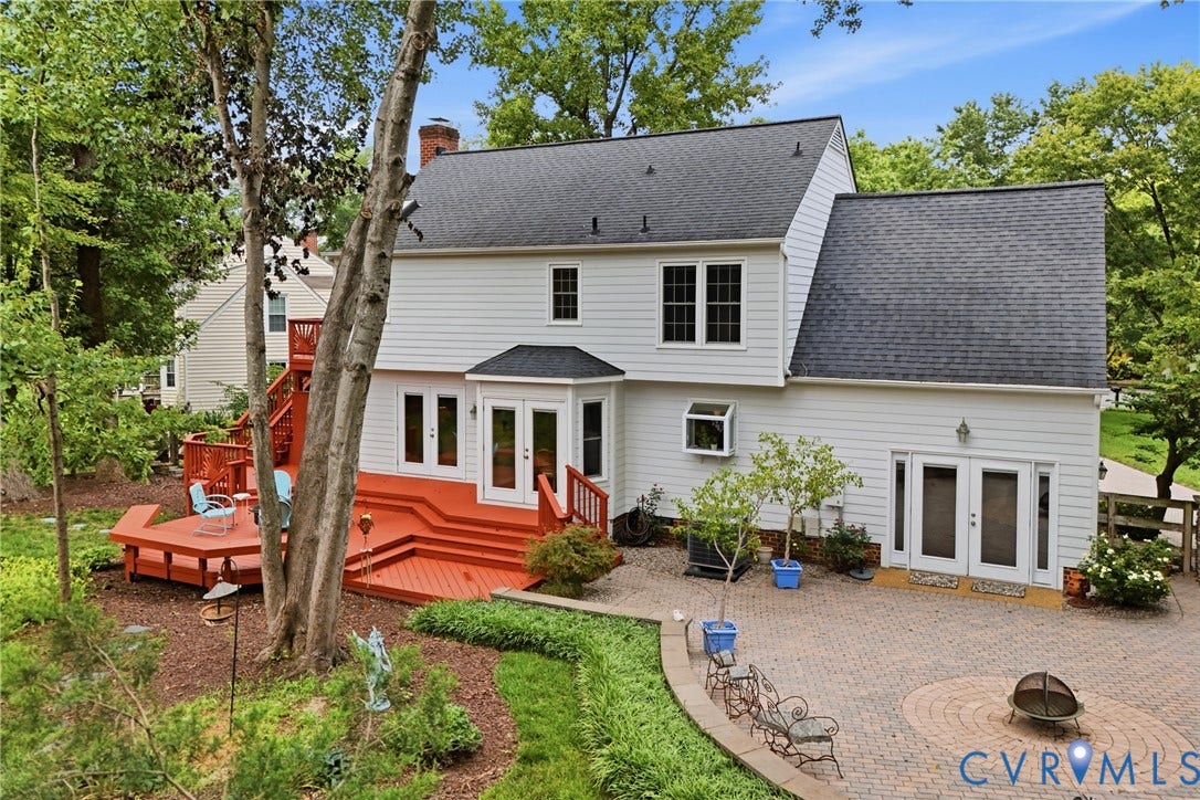 Classic Colonial home featuring a bright white exterior with black shutters and a welcoming covered front porch