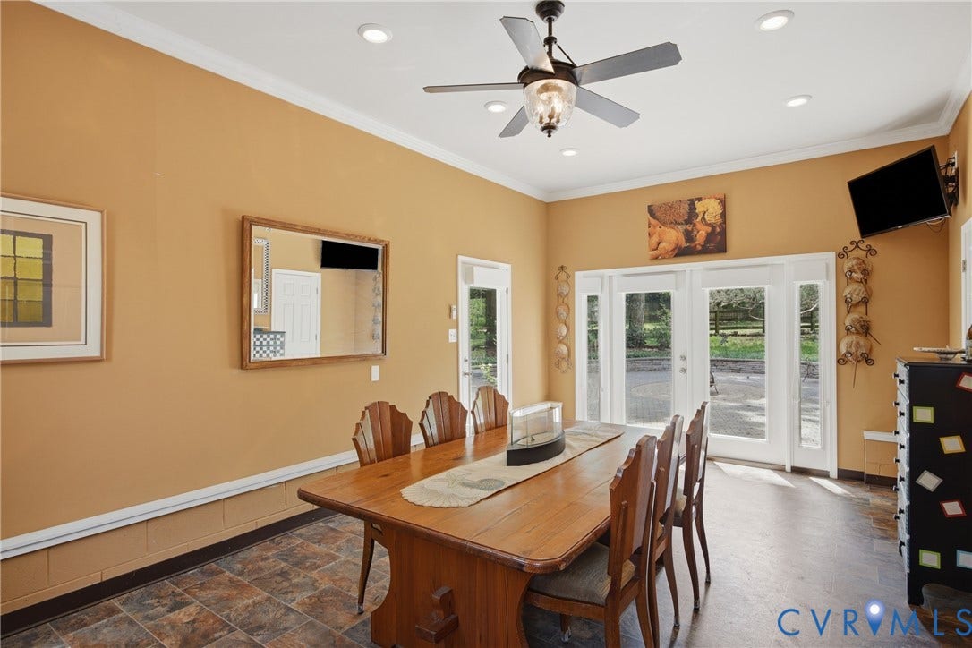 French doors with sidelights lead to the stone paved patio, and side door to the driveway