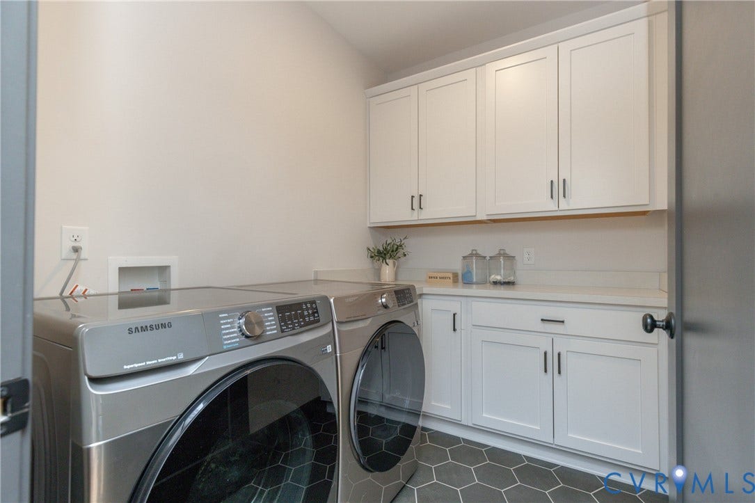 4600 Otter Court, Moseley, VA 23120 Laundry room featuring white shaker cabinetry, light-toned countertops, and dark hexagonal floor tiles