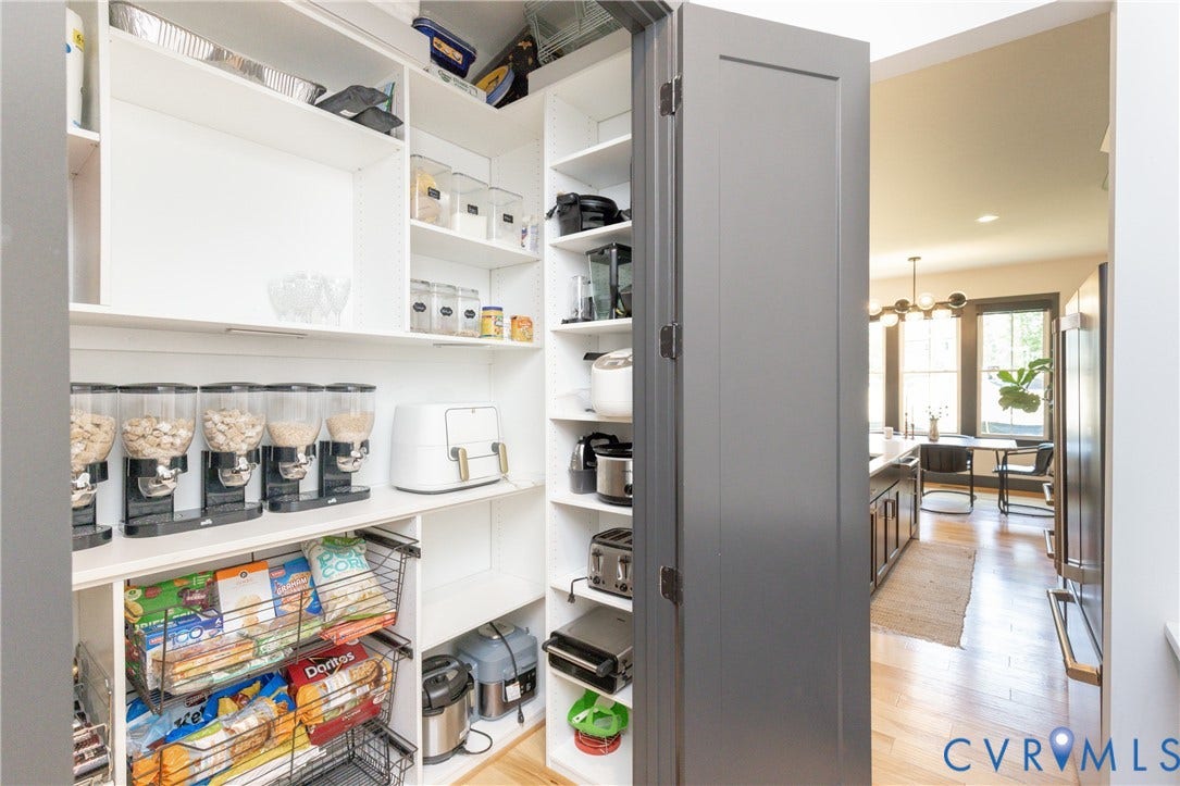 4600 Otter Court, Moseley, VA 23120 Organized pantry featuring floor-to-ceiling white cabinetry with glass-front doors, adjustable shelving, and ample storage for dry goods and pantry staples