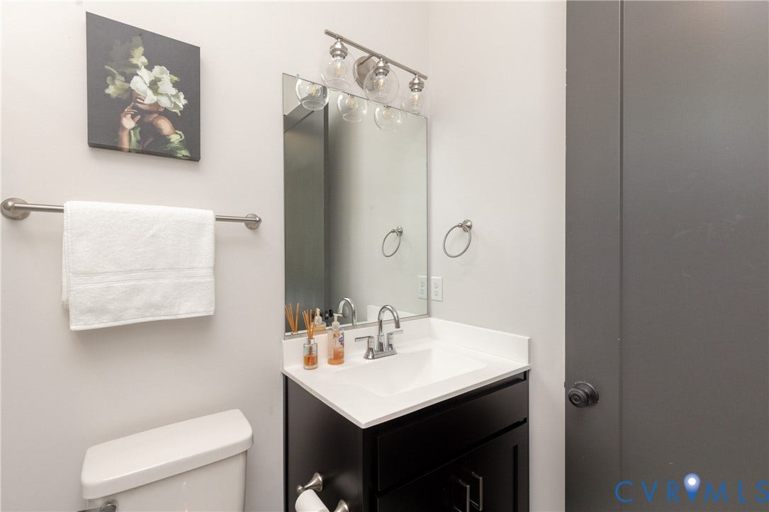 4600 Otter Court, Moseley, VA 23120 Bathroom vanity featuring a white countertop with an integrated sink, brushed nickel hardware, and a three-light vanity fixture