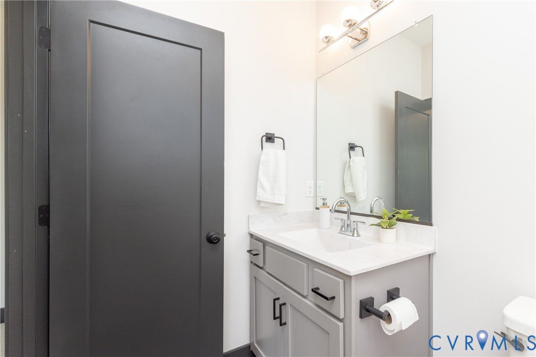 4600 Otter Court, Moseley, VA 23120 Bathroom vanity with a white countertop and integrated sink, gray cabinetry, brushed nickel faucet, and a large wall-mounted mirror
