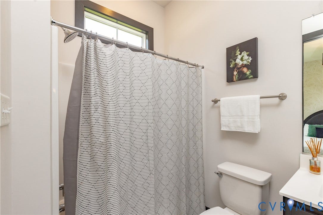 4600 Otter Court, Moseley, VA 23120 Bathroom featuring a white toilet, chrome shower fixtures, and a window with dark trim
