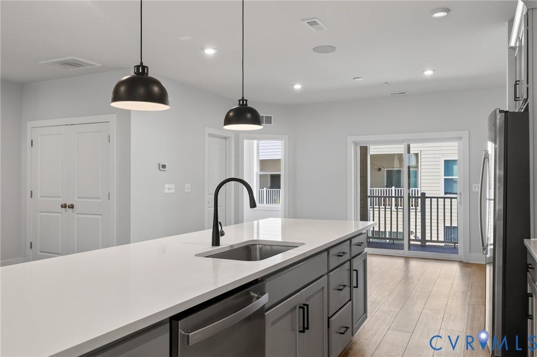 1509 Moore Street, #B, Richmond, VA 23220 Kitchen island featuring a stainless steel sink, black gooseneck faucet, and pendant lighting