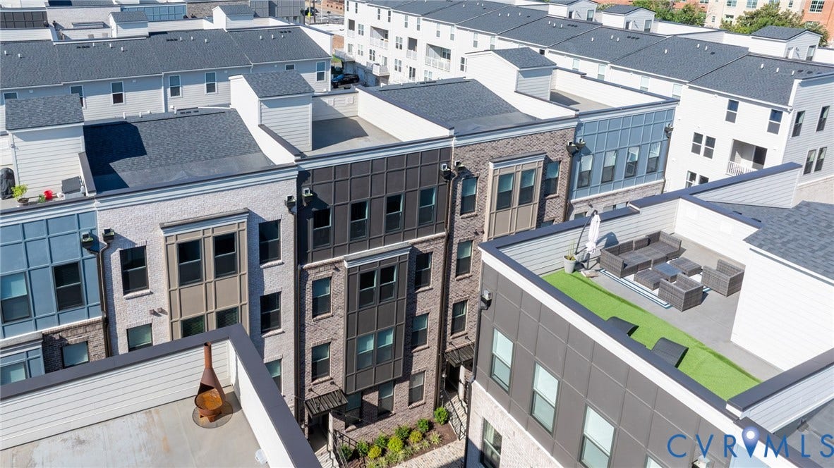 1509 Moore Street, #B, Richmond, VA 23220 Multi-level townhome featuring a rooftop terrace with artificial turf, dark gray siding, and multiple windows
