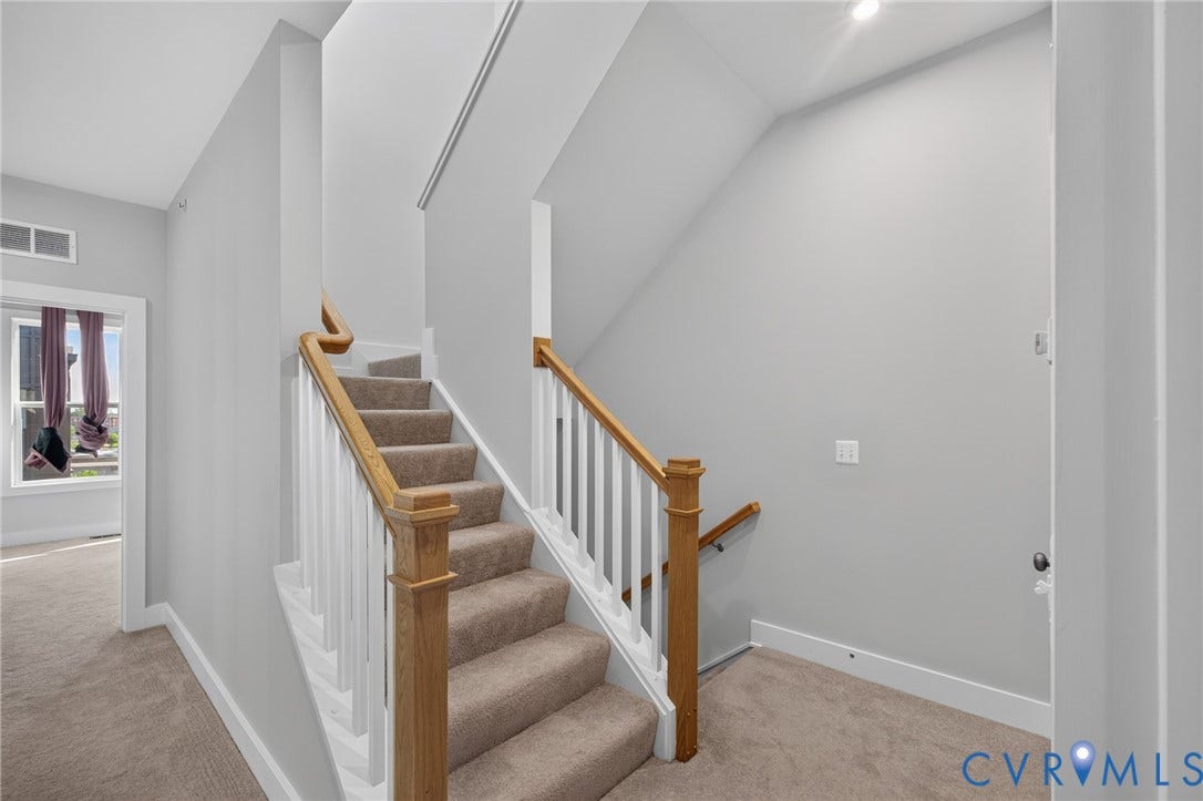 1509 Moore Street, #B, Richmond, VA 23220 Carpeted staircase with wood handrails and white balusters, featuring a neutral color palette and recessed lighting