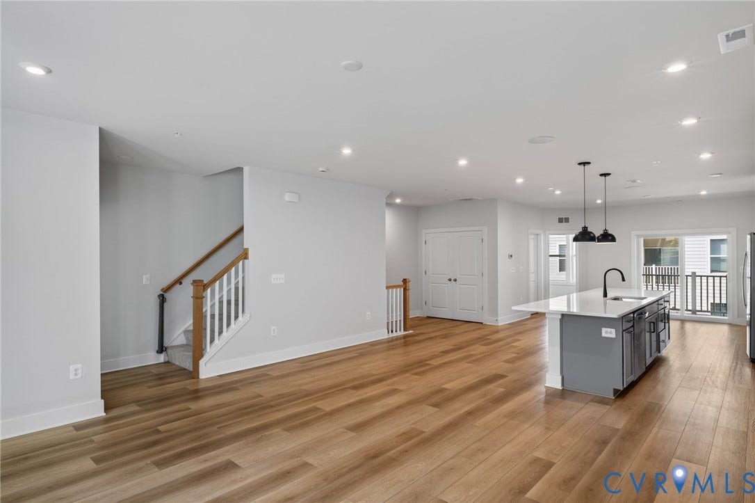 1509 Moore Street, #B, Richmond, VA 23220 Open-concept living space featuring wood-finish flooring, recessed lighting, and a kitchen island with a white countertop and dark pendant lights