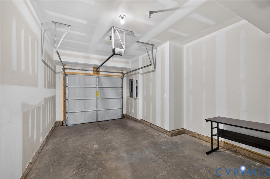 1509 Moore Street, #B, Richmond, VA 23220 Attached garage with a roll-up door, exposed ceiling joists, and concrete flooring