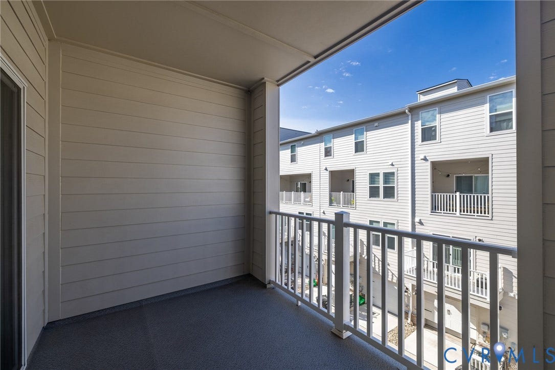 1509 Moore Street, #B, Richmond, VA 23220 Covered balcony with a sliding glass door, white railing, and grey flooring