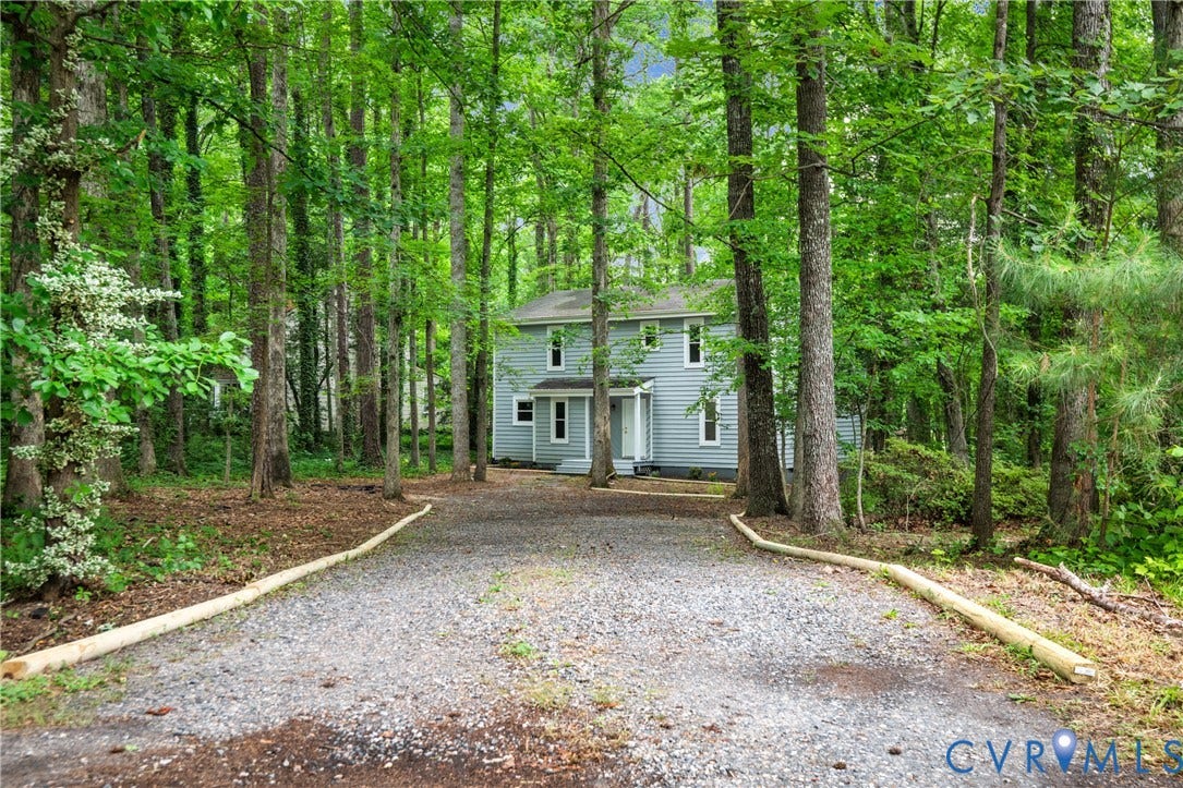 2903 Fox Chase Drive, Huntsbridge, Midlothian, VA 23112 Two-story residence featuring light blue siding, a gravel driveway, and a natural tree-lined setting