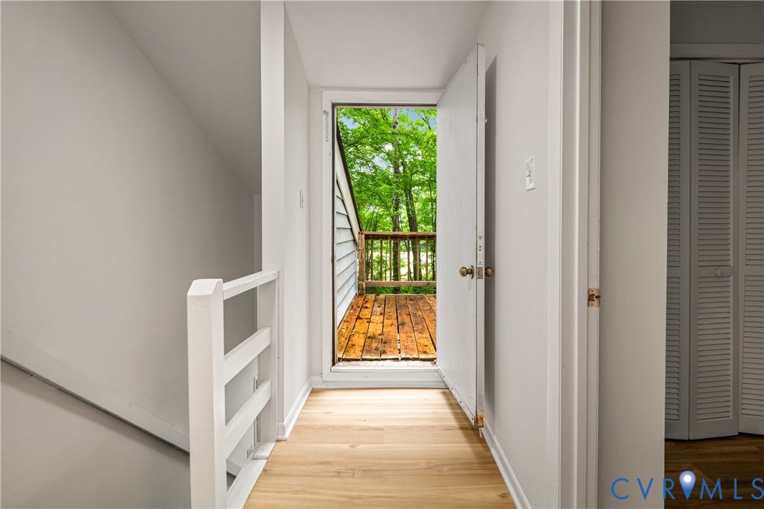 2903 Fox Chase Drive, Huntsbridge, Midlothian, VA 23112 Bright hallway with hardwood flooring and white trim, opening to a spacious deck with wooden decking and lush tree canopy backdrop