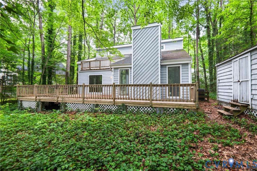 2903 Fox Chase Drive, Huntsbridge, Midlothian, VA 23112 Modern elevated home featuring a striking vertical architectural element and horizontal siding, set on a wooded lot with mature trees