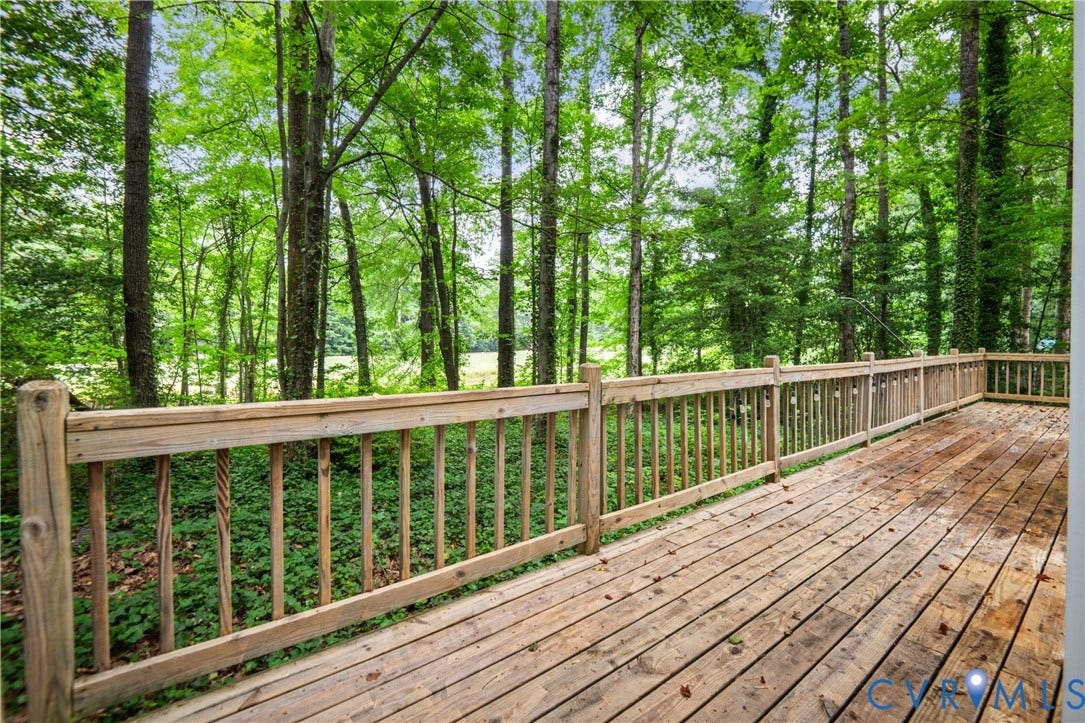 2903 Fox Chase Drive, Huntsbridge, Midlothian, VA 23112 Expansive composite deck featuring pressure-treated wood decking with integrated wooden railings and balusters, overlooking a mature forest canopy
