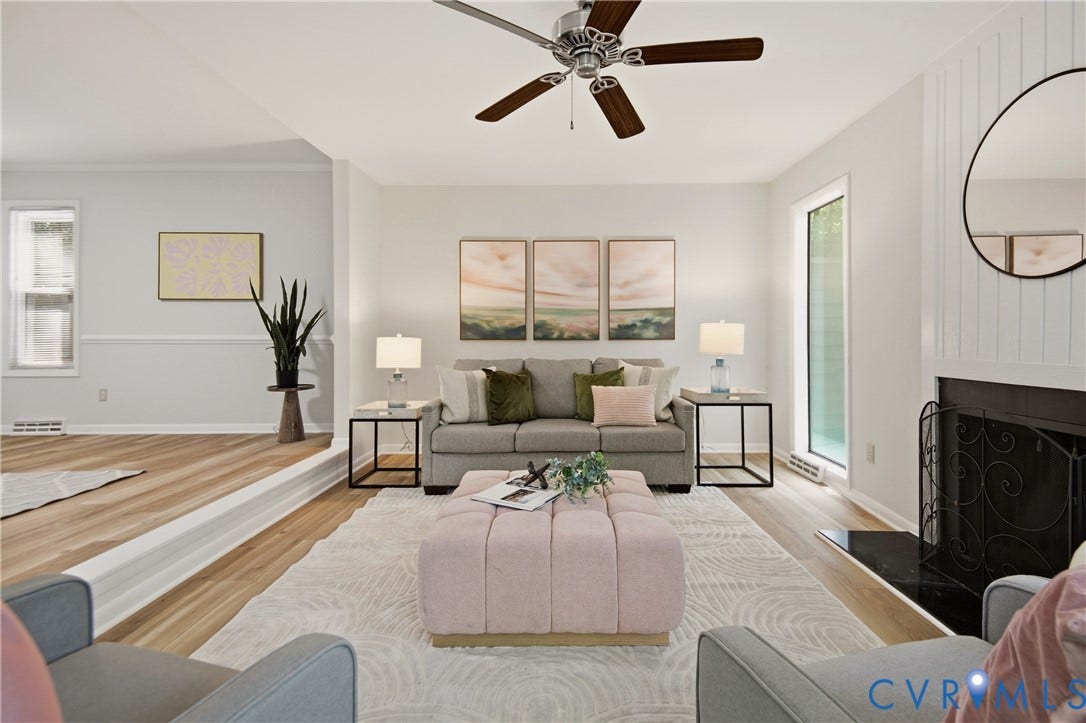 2903 Fox Chase Drive, Huntsbridge, Midlothian, VA 23112 Living room featuring wood-finish flooring, a fireplace with a black hearth, a ceiling fan with dark wood-finish blades, and a built-in step separating distinct areas