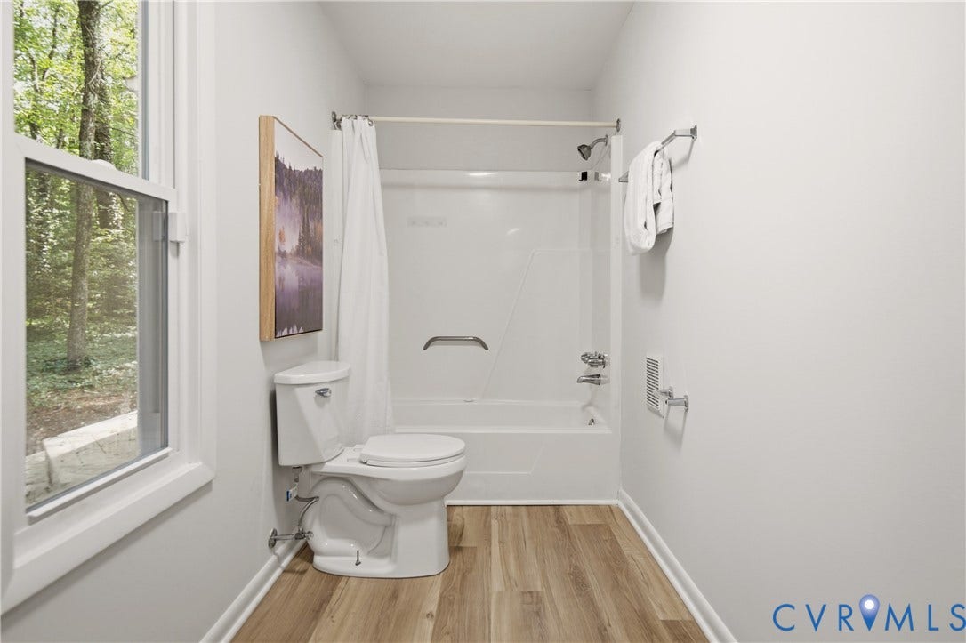 2903 Fox Chase Drive, Huntsbridge, Midlothian, VA 23112 Bathroom featuring wood-finish flooring, a white window frame, a built-in tub and shower combination with a grab bar, and a white toilet