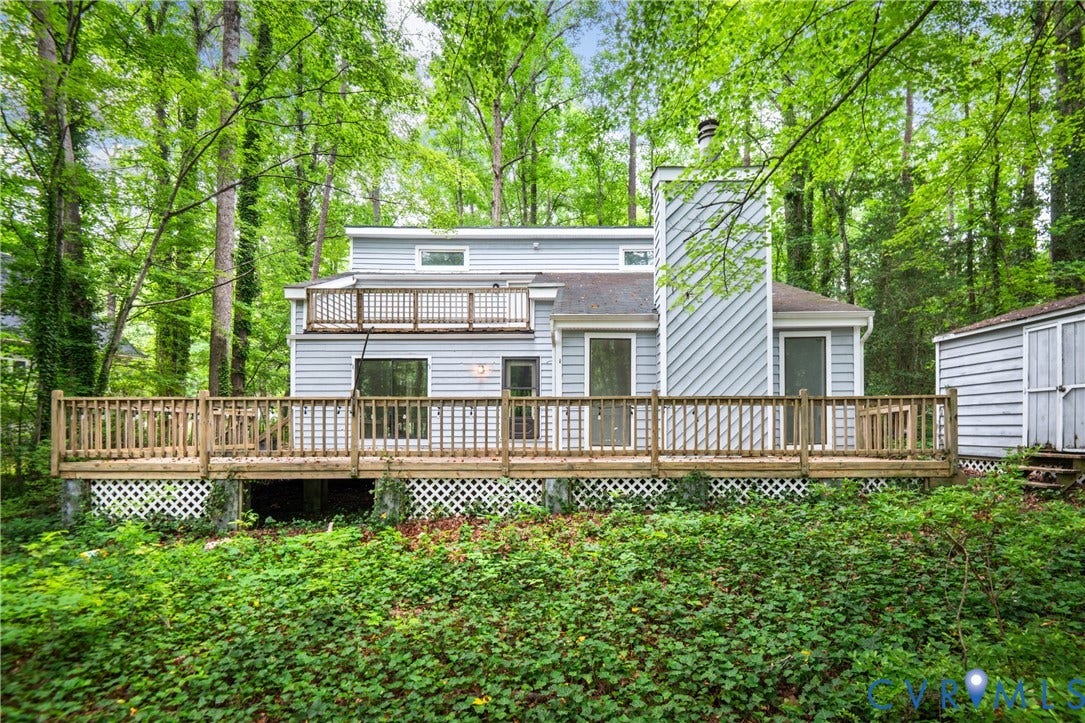 2903 Fox Chase Drive, Huntsbridge, Midlothian, VA 23112 Contemporary home with expansive deck featuring wood railings and lattice detailing, set on a wooded lot with mature trees and natural landscaping
