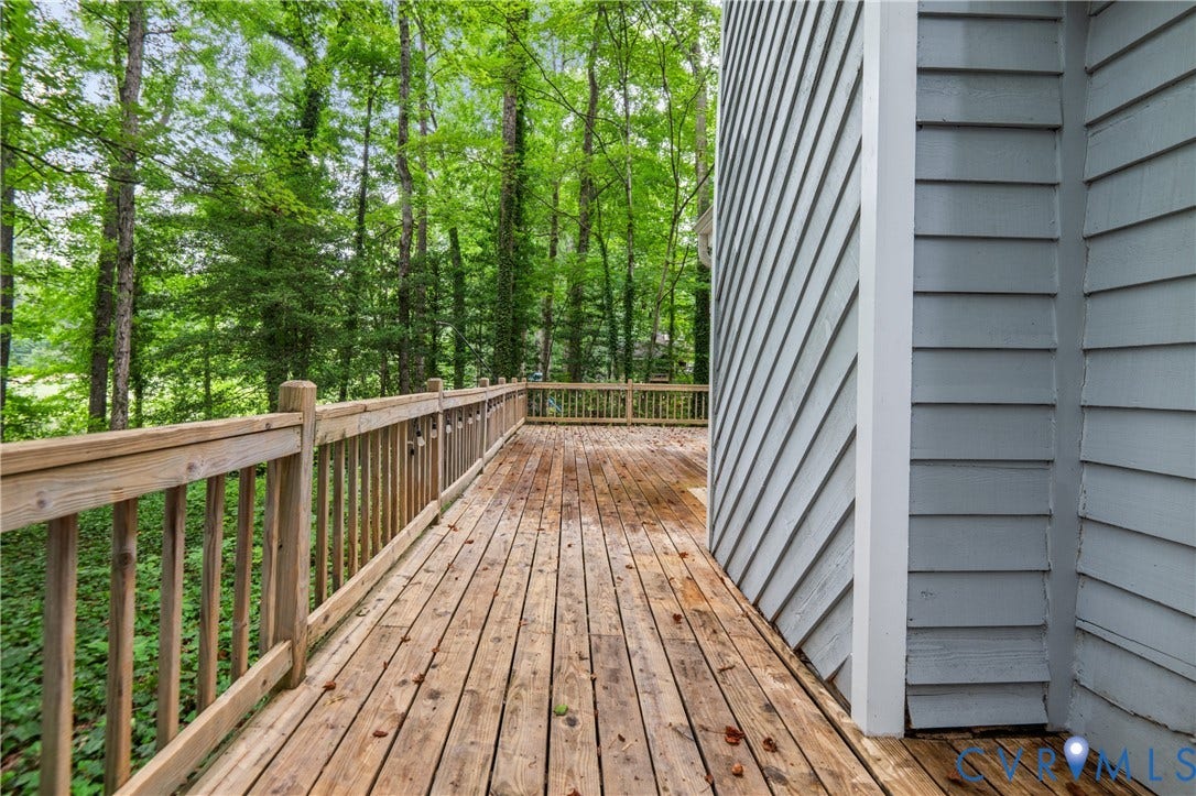 2903 Fox Chase Drive, Huntsbridge, Midlothian, VA 23112 Expansive composite deck featuring rich wood-finish planking, sturdy balusters, and metal railings overlooking mature wooded landscape