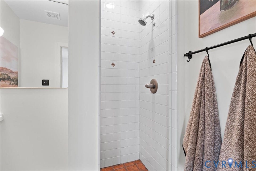 2510 E Leigh Street, Church Hill, Richmond, VA 23223 Shower with white subway tile surround, accent tiles, and a bronze-finish shower fixture