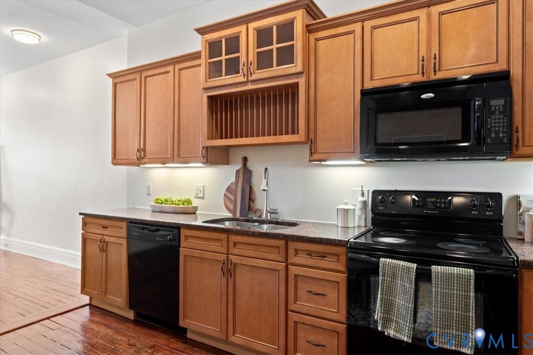 2510 E Leigh Street, Church Hill, Richmond, VA 23223 Kitchen featuring wood-finish cabinetry, dark countertops, a built-in microwave, and a black range