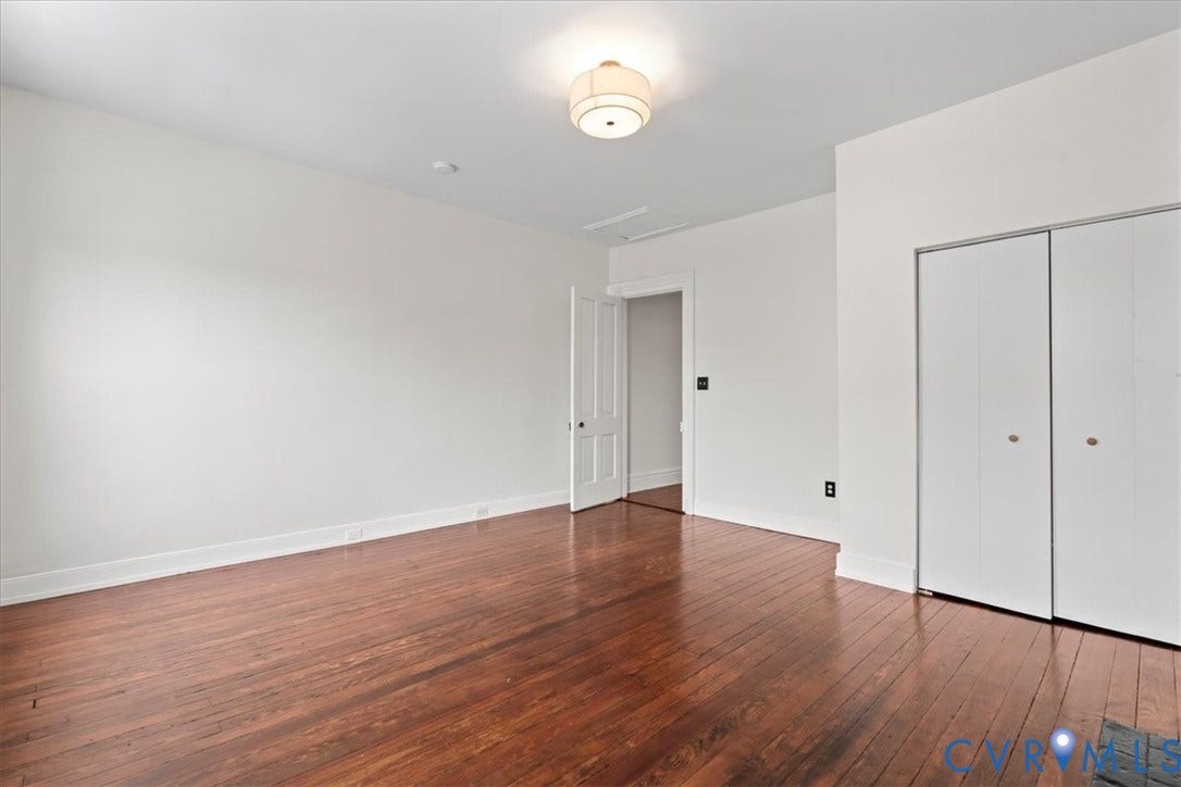 2510 E Leigh Street, Church Hill, Richmond, VA 23223 Hardwood flooring, white walls, flush mount ceiling light, white bi-fold closet doors, and white interior door