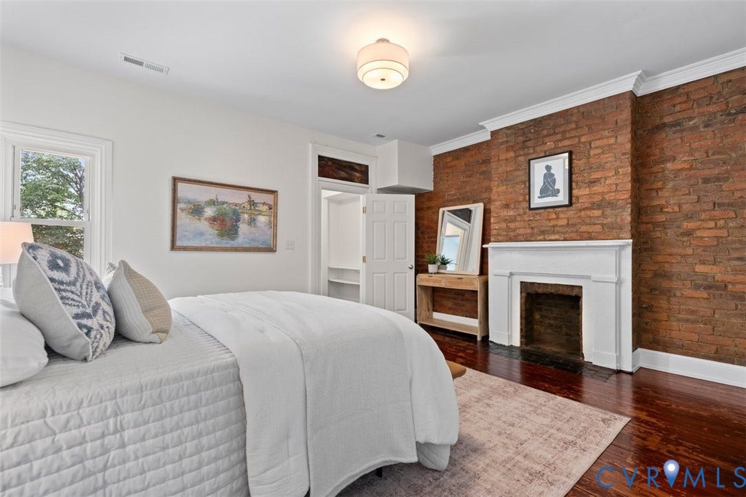 2510 E Leigh Street, Church Hill, Richmond, VA 23223 Exposed brick wall, hardwood flooring, white crown molding, a built-in fireplace with a white mantel, and a window with white trim