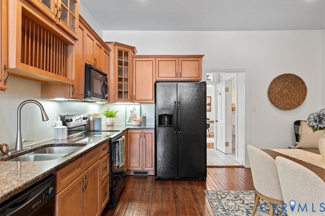 2510 E Leigh Street, Church Hill, Richmond, VA 23223 Wood-finish flooring, L-shaped counter, under-cabinet lighting, black appliances, and wooden cabinetry