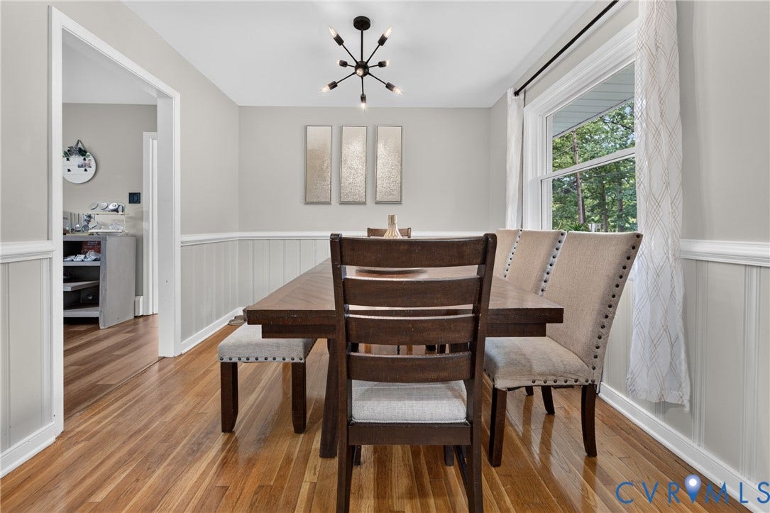 3401 Austin Avenue, Brentwood, Henrico, VA 23222 Hardwood flooring throughout this room, featuring wainscoting, a modern sputnik-style chandelier, and a large window