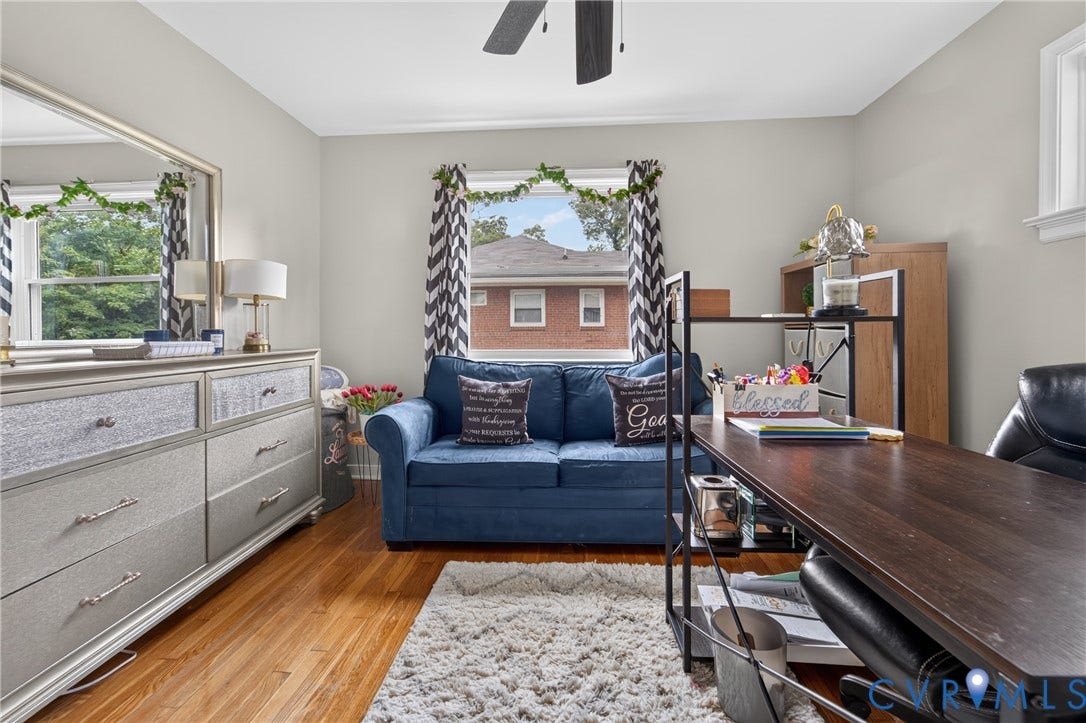 3401 Austin Avenue, Brentwood, Henrico, VA 23222 Hardwood flooring enhances this versatile room, featuring light gray walls, a window with natural light, a ceiling fan, and white trim